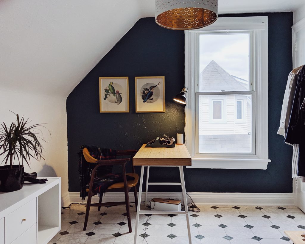 Home office painted white with a navy blue accent wall