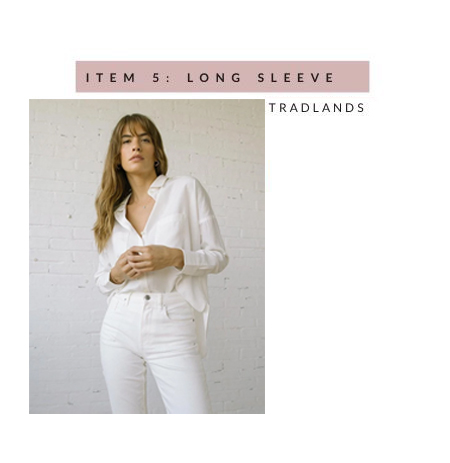 Tradlands' long sleeve Box Top in salt - a woman standing in front of a white brick wall wearing it with white jeans